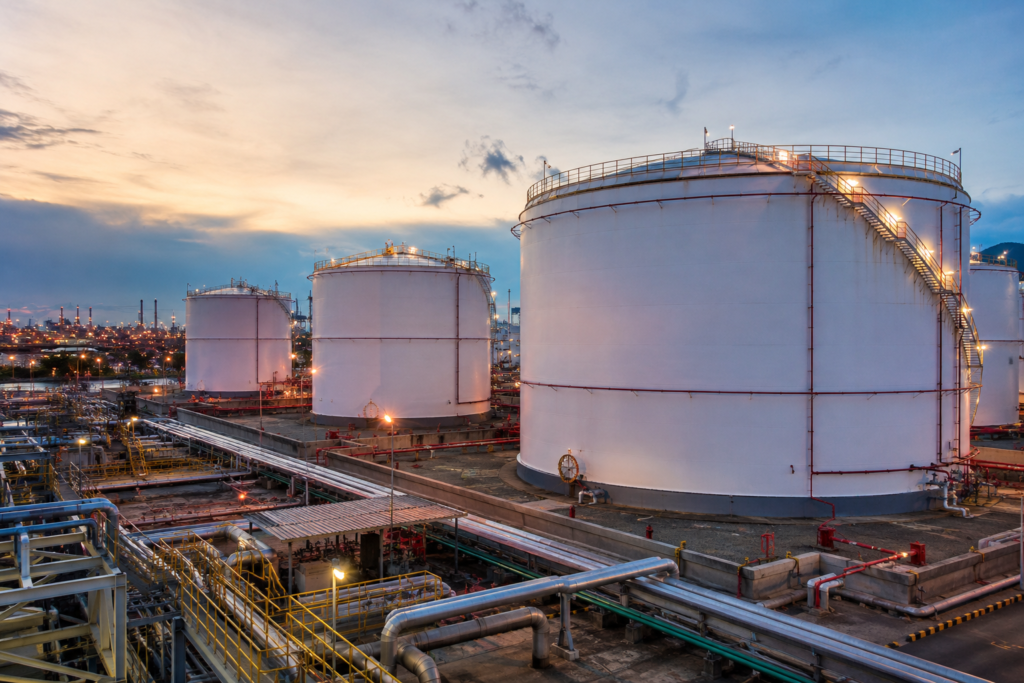 Large petroleum storage tanks and industrial pipeline network at an oil storage terminal.