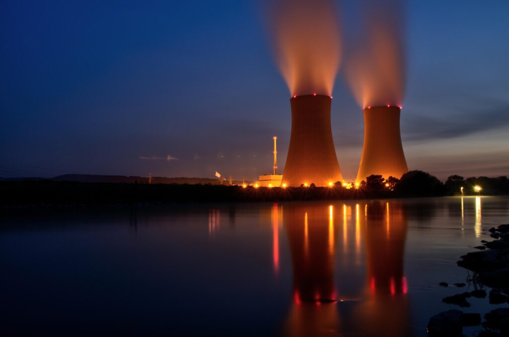 Power generation facility with cooling towers operating during evening hours.